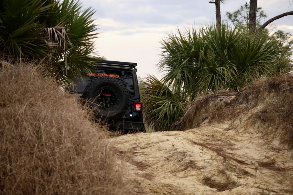 Branded Jeep Willys climbing a sandy ridge in Southwest Florida, representing professional off-road expedition and adventure media services.